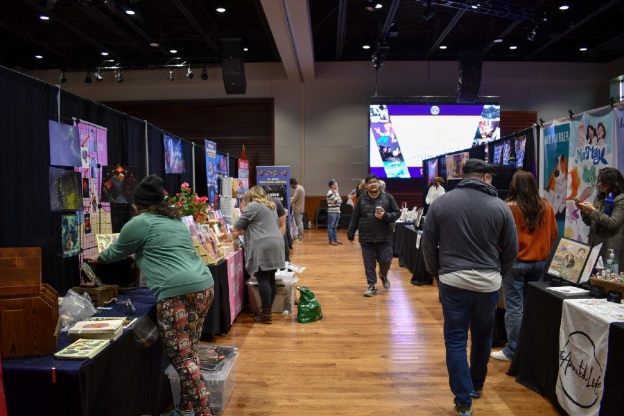 people walking around looking at animation exhibitor booths. 