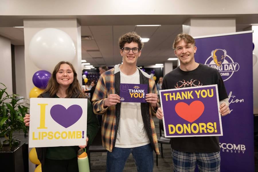 Students holding up signs that say thank you. 