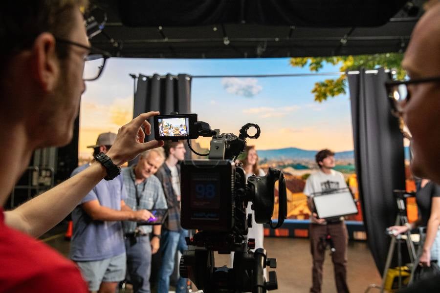Students at the volume wall filming a scene. 