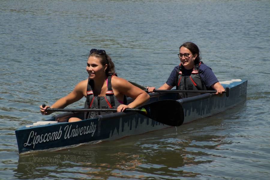 Students on the river in the concrete canoe