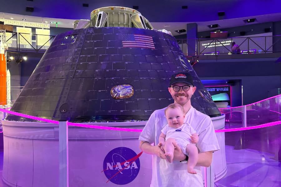Sears holding his infant son in front of the very first Orion spacecraft at Kennedy. 