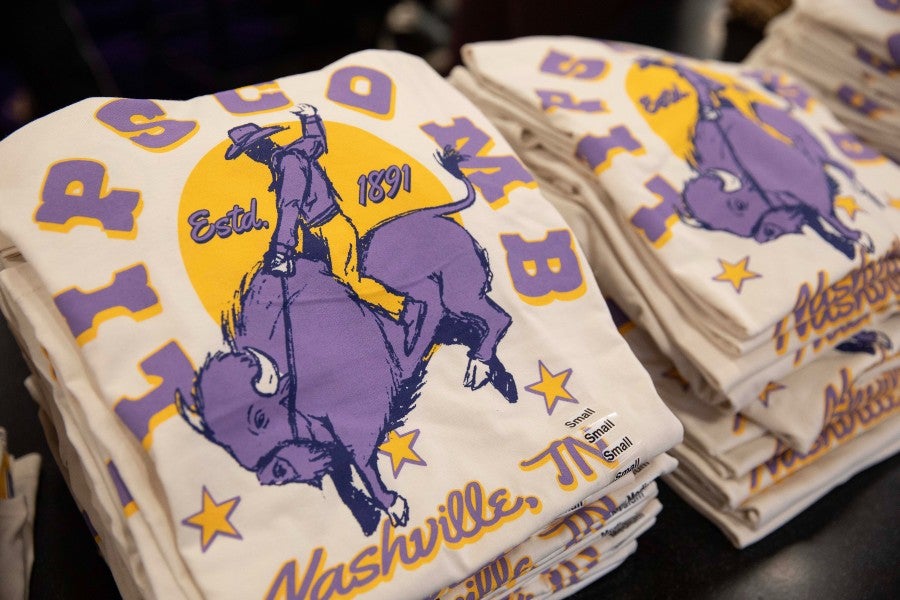 Stacks of T-shirts with Trey Merrill's designs for sale