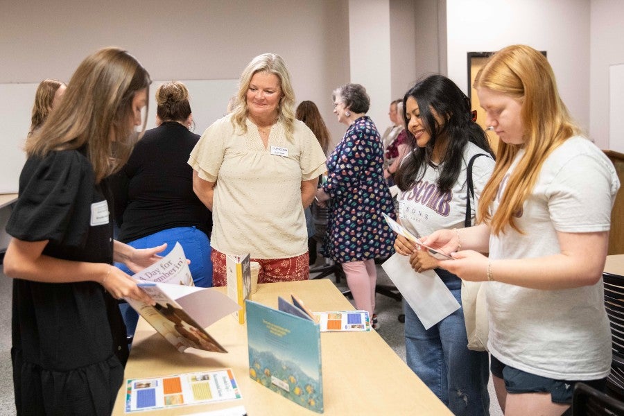 Suze Gilbert and students talking with teachers at the conference