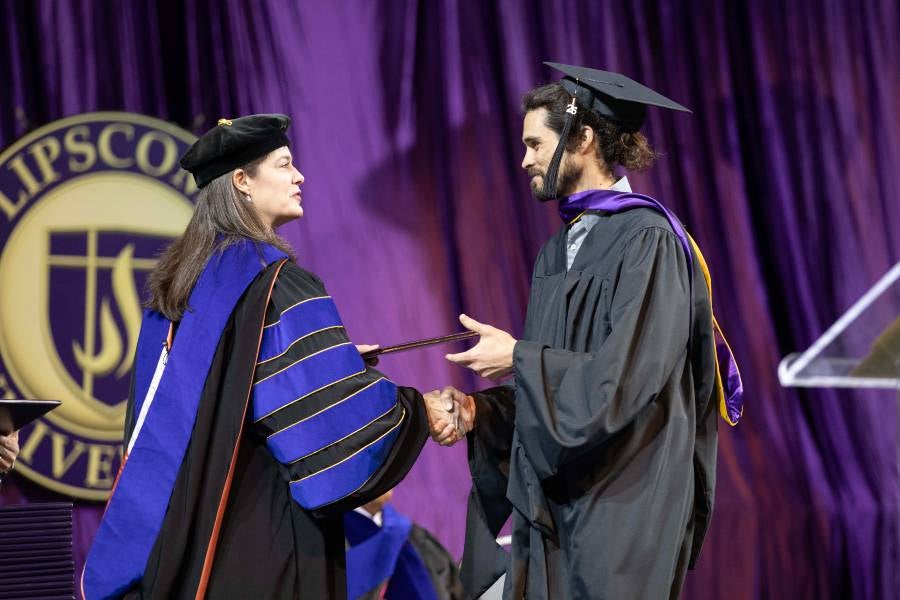 Student getting graduate degree from President McQueen. 