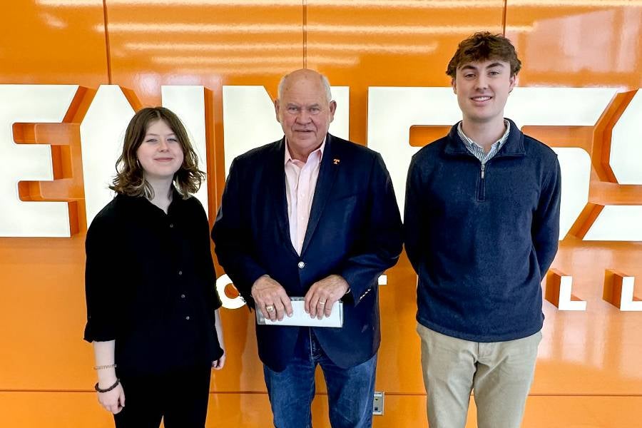 Two students standing with former UT football coach Phil Fulmer.