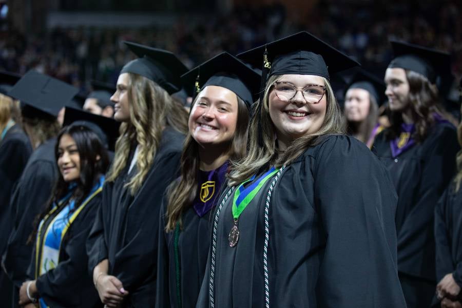 Two female students in the undergraduate crowd. 