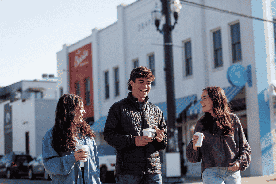 Students walking in 12th Avenue South with coffees in hand