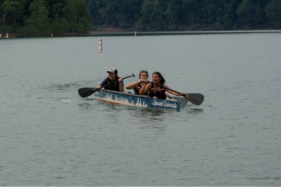 Three members of the Lipscomb concrete canoe team paddling in the water. 