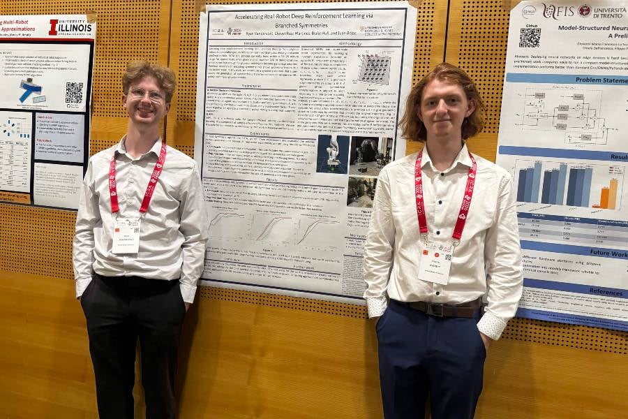 two student presenters in front of their poster at the Vienna conference