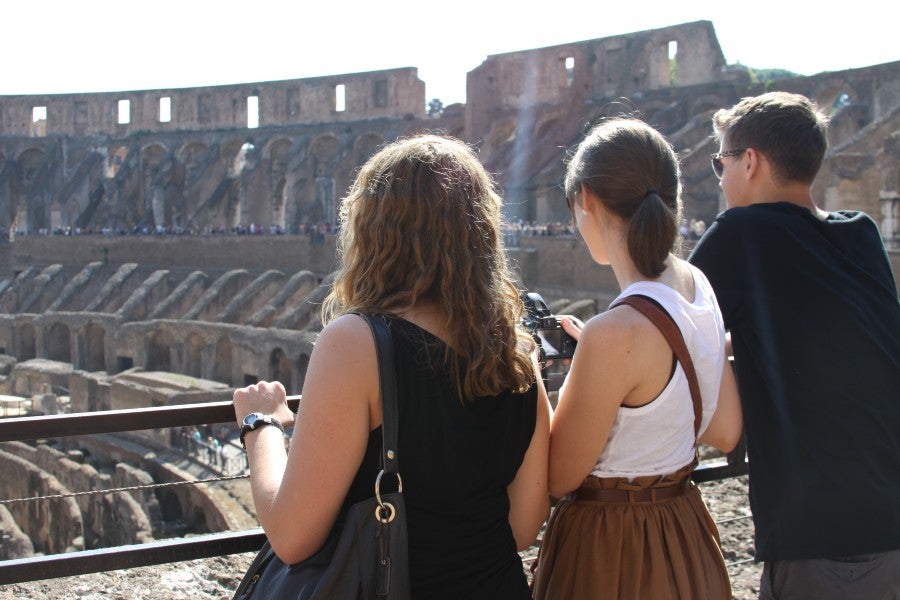 three students looking over the interior of the Colosseum in Rome