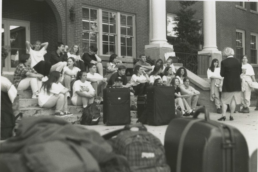 students who went on the first trip to Vienna in 1996 waiting on on the steps of a dorm to head off to the airport