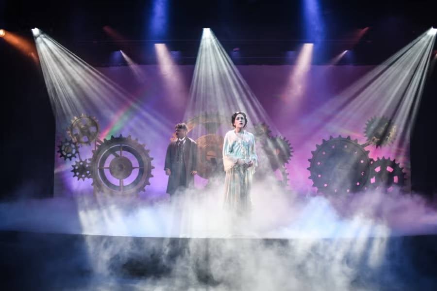 View of a student actors on stage in Collins Alumni Auditorium. 