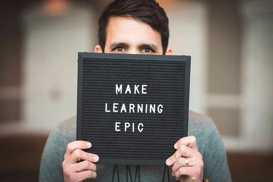 Trevor Muir holds sign saying: Make Learning Epic