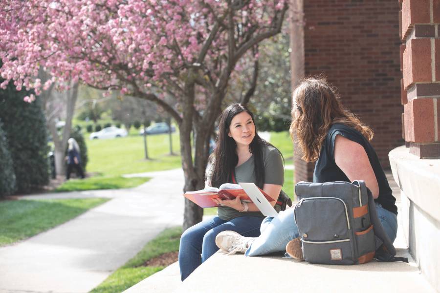 Two students sitting outside studying. 