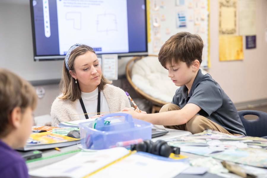 Teacher with student in school activity. 