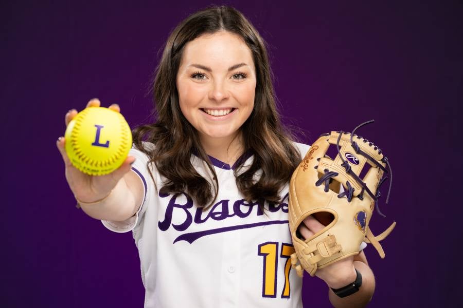 Elise Shewmaker holding a softball and glove.