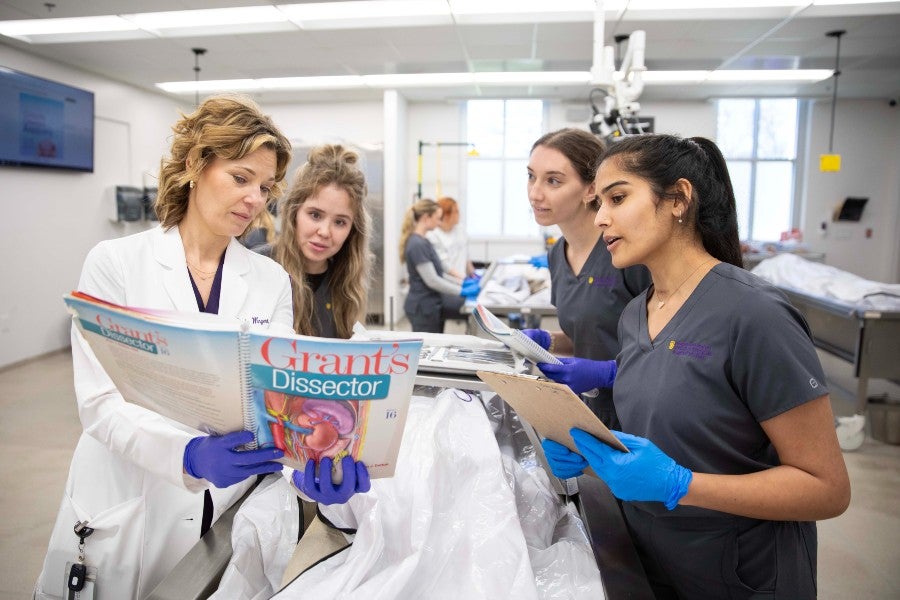 Professor instructing health science students in anatomy class