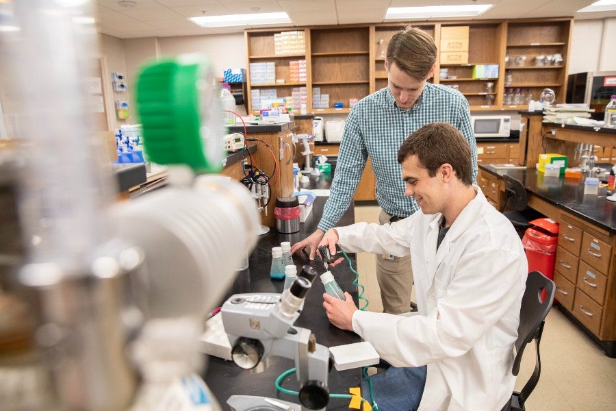 Lipscomb biology faculty Josh Owens works with Jackson head in the biology lab