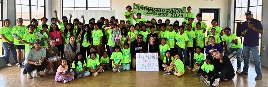 Lipscomb softball players pose with a group of children at Baja Missions
