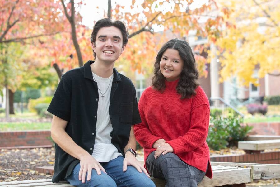 Lucas Collins and Amada Lashmit-Pena sitting outside on a fall day at Lipscomb. 