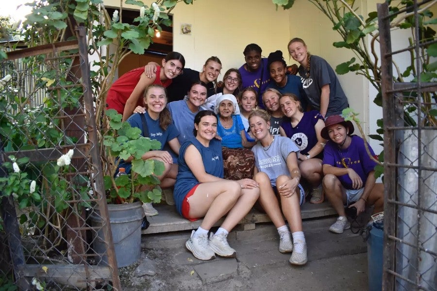 Students posing with a locale in El Salvador