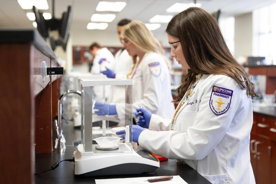 Three students in the College of Pharmacy lab. 