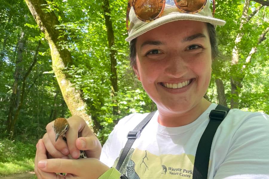 Lexi Price out in Warner Parks holding a bird during a research project. 