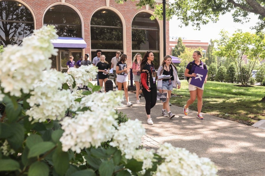 Student orientation staff leading students across campus