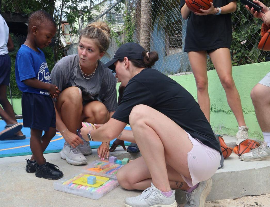 Students playing with local child