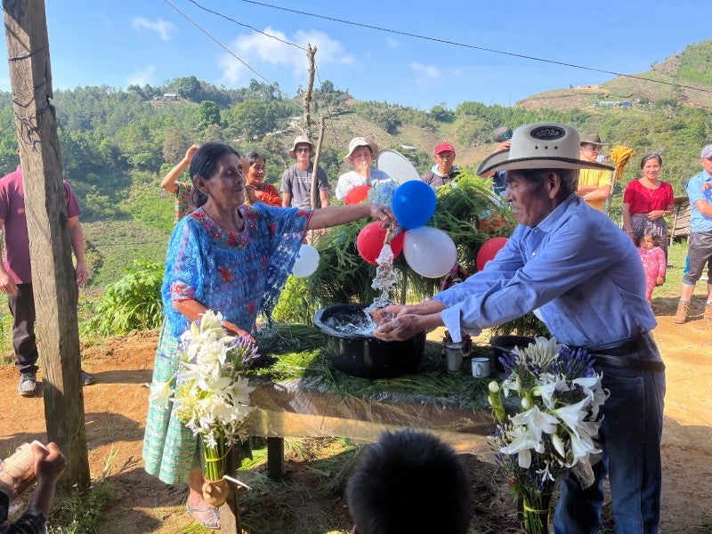 2 locals celebrating the running water they received from the spout.