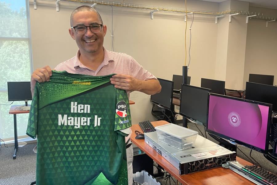Ken Mayer, associate professor in the School of Computing, shows off his official Pro Bowling Association jersey.