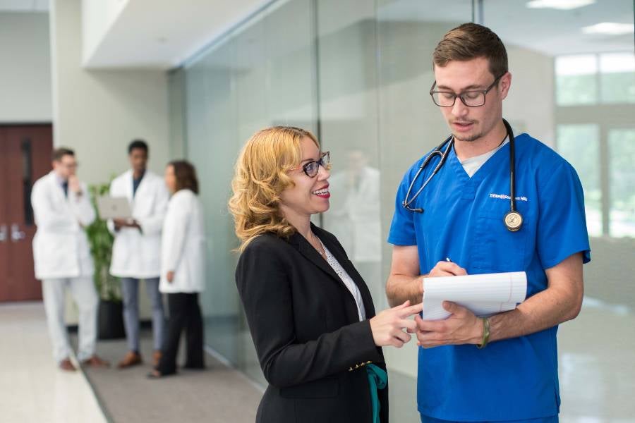 Two individuals looking over a medical chart. 