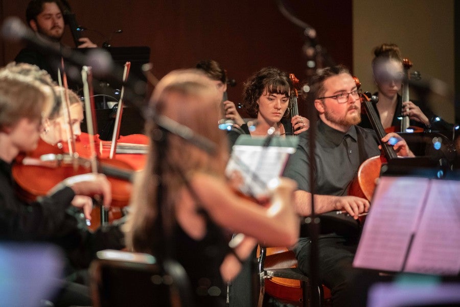 student playing string instruments at an orchestra concert