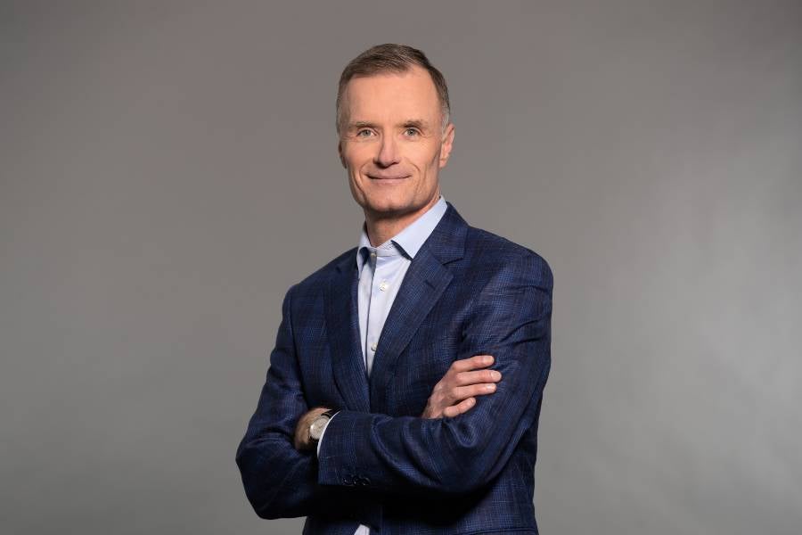 Photo of Craig Cordola standing with arms crossed. 