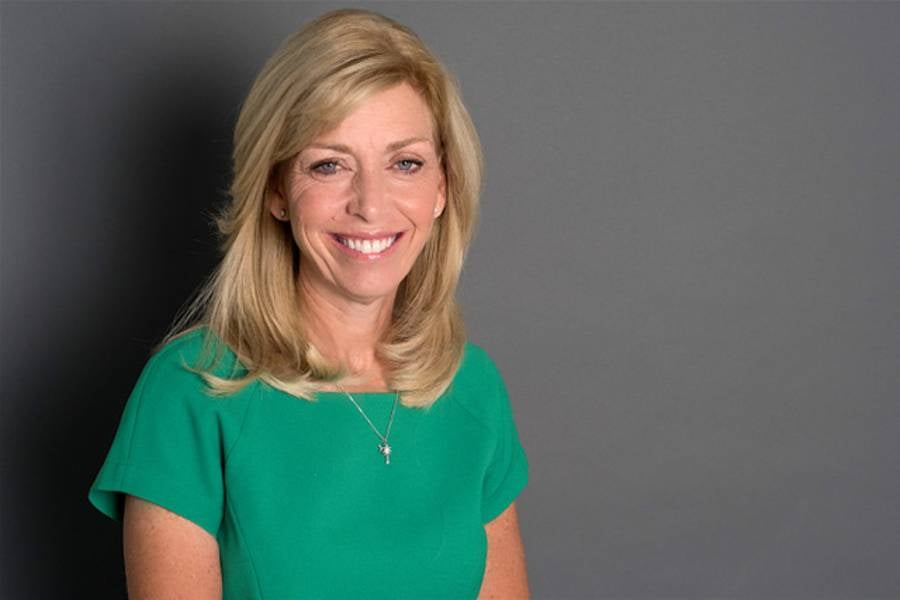 Photo of Beth DeBauche in front of a gray background. 