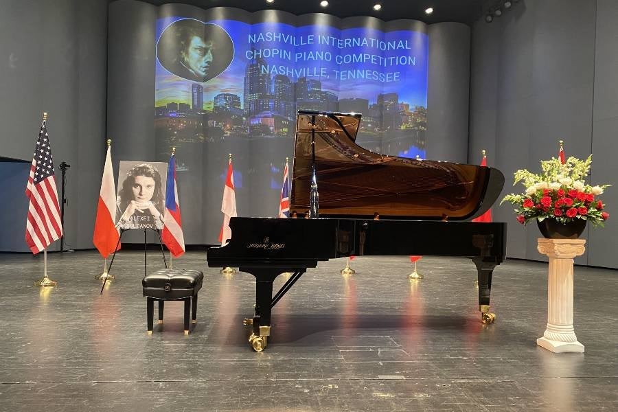 Grand piano on stage with country flags surrounding it