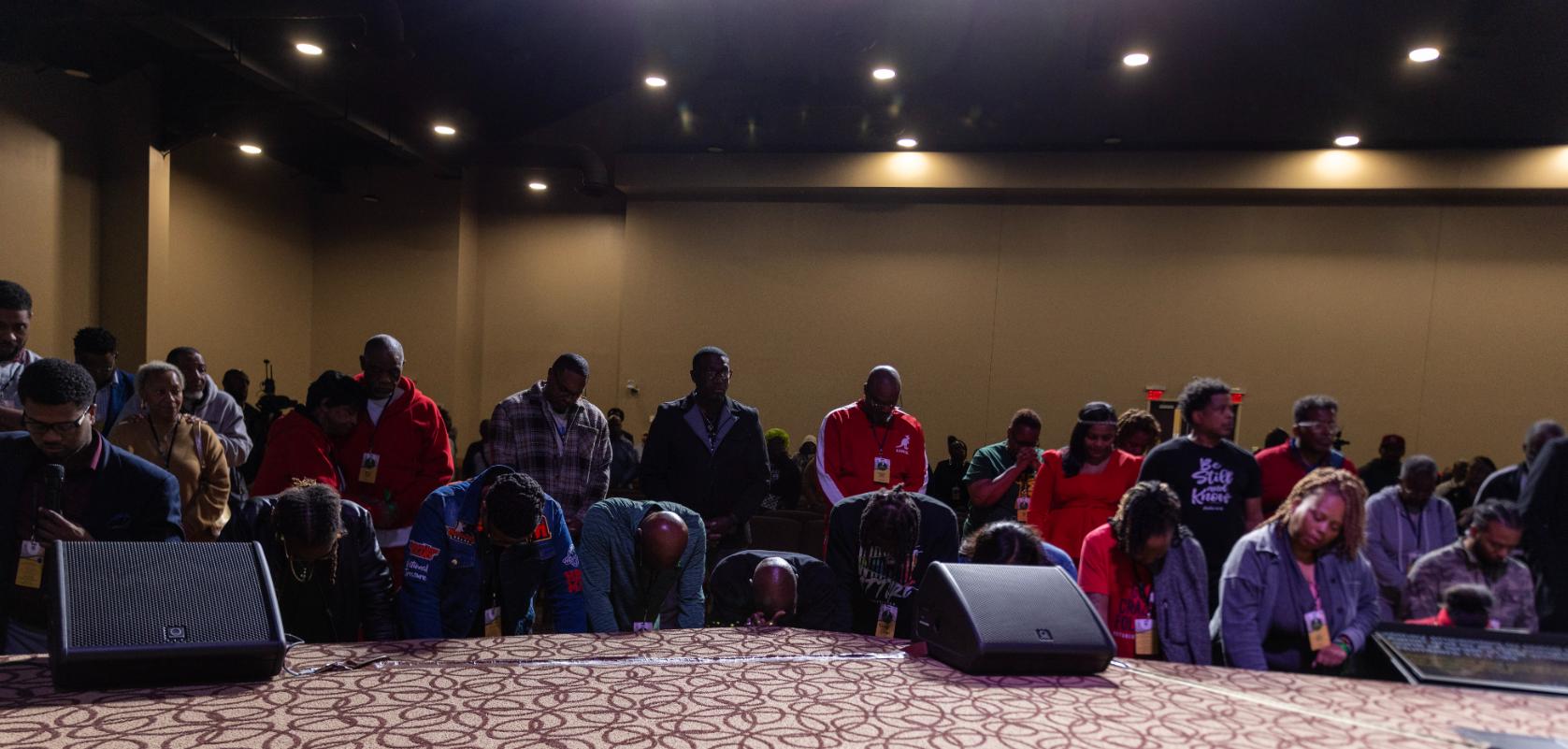 Attendees bowed together in prayer