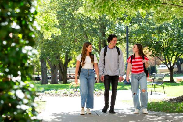 Three students standing outside and talking