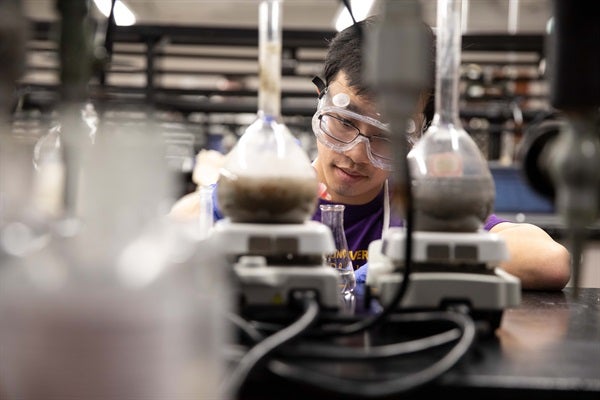 chemist behind beakers and equipment