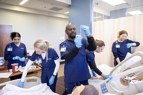 nursing students practicing on fake patient
