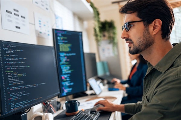 man sitting at a desk coding