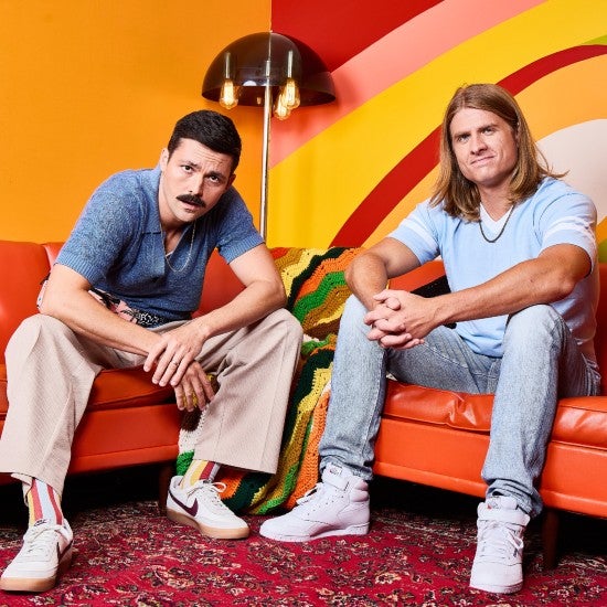 Austin & Colin posing on orange couches