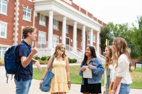 Five students standing on the Lipscomb campus talking. 