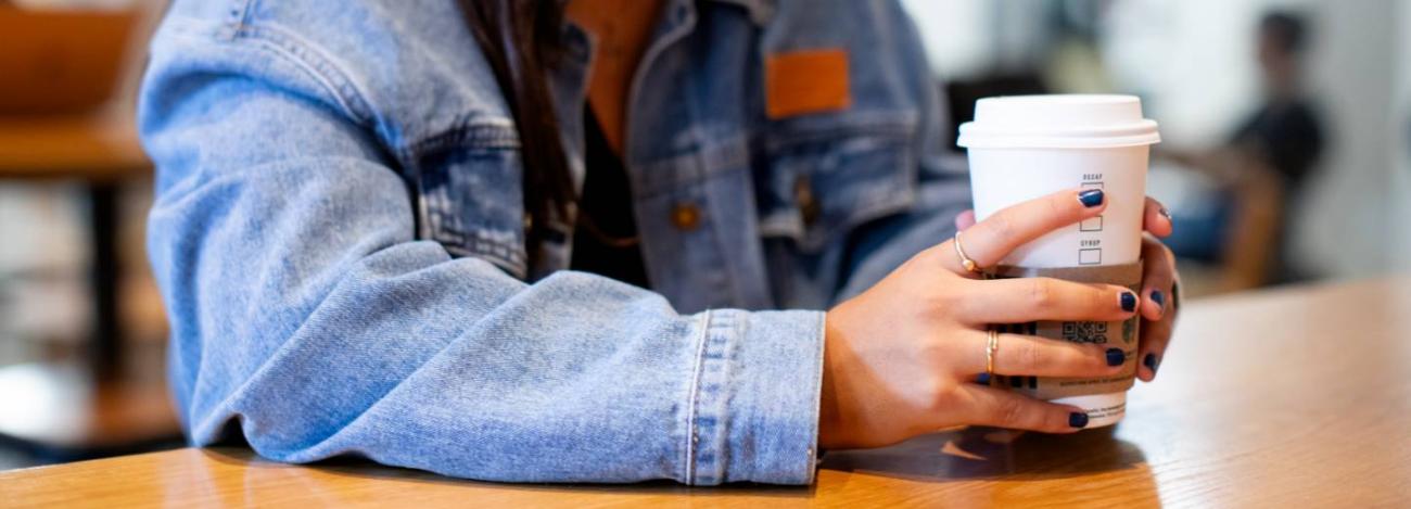 student with starbucks coffee in her hand