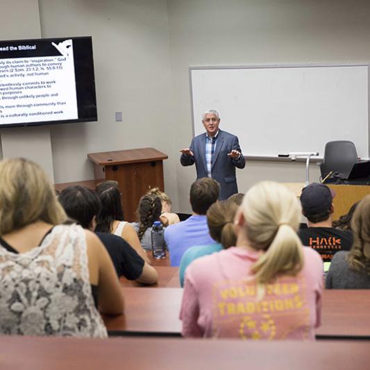 A professor teaches theology students in a classroom