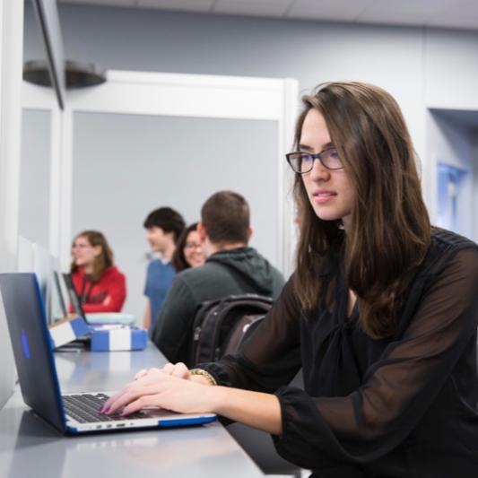 Woman typing on computer in computer lab