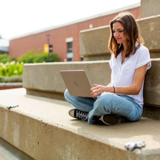 Student on laptop outside