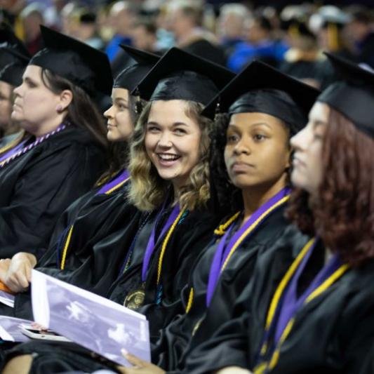 Graduating student smiles in her row