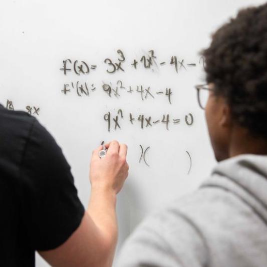 Students writing on a whiteboard in the math lab