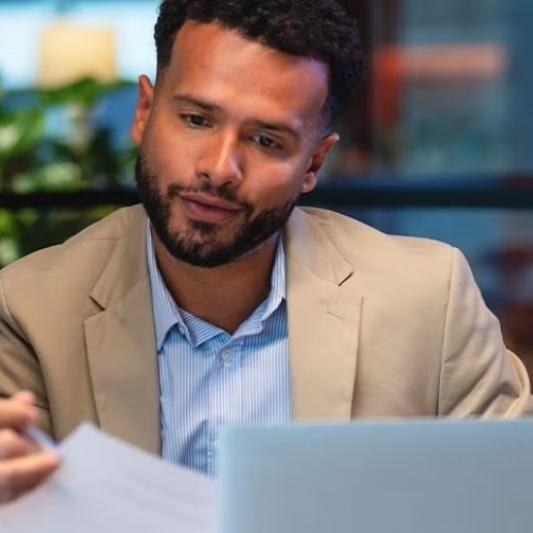A businessman working with a colleague and looking at his computer.